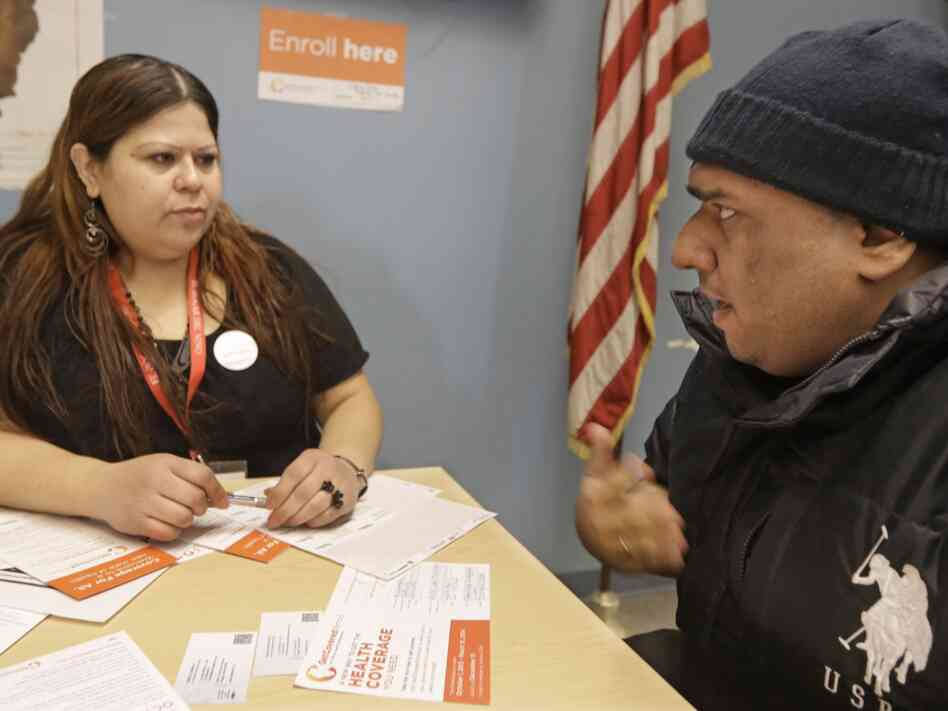 Yuvania Maldonado, a counselor for President Obama's health care law, speaks with Chicago taxi driver Mohammad Chaudri at a city office where taxi drivers go to renew their license. Yuvania Maldonado, a counselor for President Obama's health care law, speaks with Chicago taxi driver Mohammad Chaudri at a city office where taxi drivers go to renew their license.