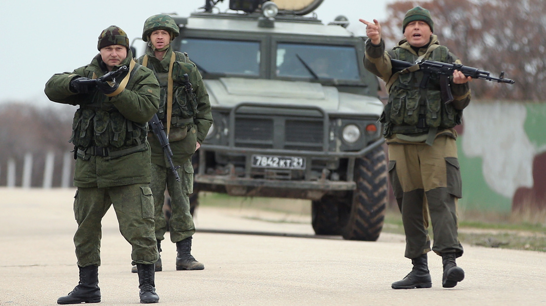 Troops under Russian command scream orders to turn back before firing warning shots at the Belbek airbase in Crimea. The troops were reacting to a large group of unarmed Ukrainian troops who approached them.