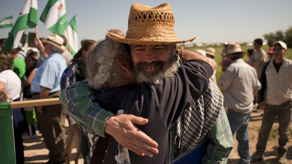 Radical Mayor Sanchez Gordillo objects to agricultural subsidies for the land elite. At a rally, he embraces a unionista who wanted to start a communal agricultural project on military-owned land. Radical Mayor Sanchez Gordillo objects to agricultural subsidies for the land elite. At a rally, he embraces a unionista who wanted to start a communal agricultural project on military-owned land.