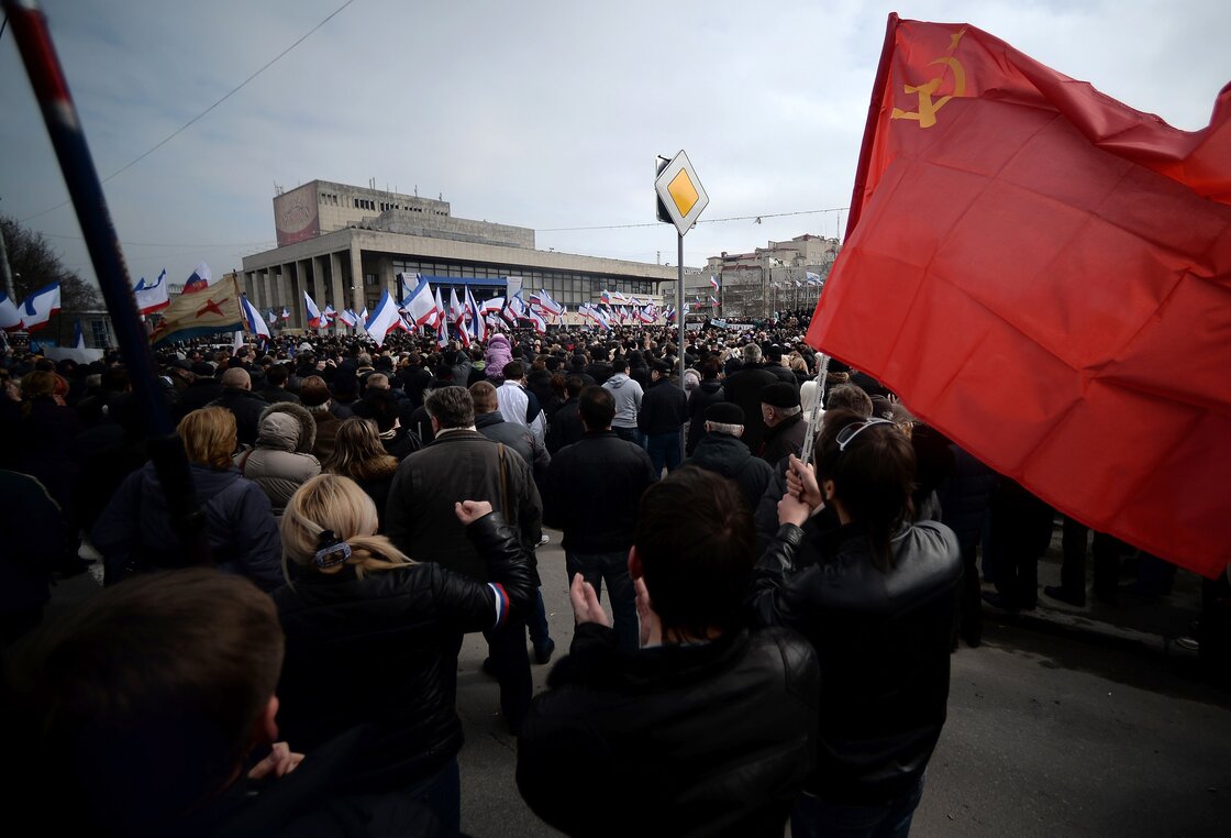 A man holds a Soviet Union flag during a pro-Russia rally in Simferopol, Crimea's Lenin Square Sunday. In Kiev, Ukrainian Prime Minister Arseniy Yatsenyuk vows not to give "an inch" of territory to Russia.