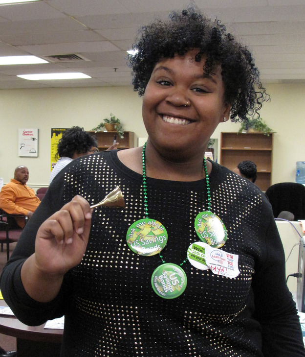 Maya Gaines, of the Baltimore CASH Campaign, tries to encourage people to put aside some of their tax refunds into savings. She rings bells, cheers and dances every time someone decides to do that. (Image credit: NPR)