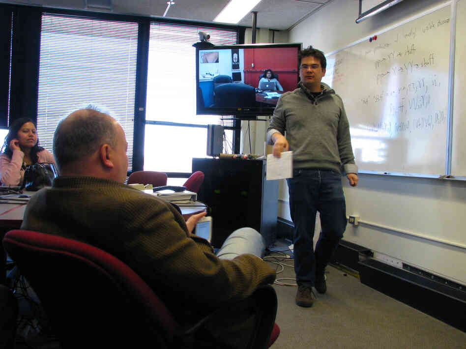 John Paul Chou (right), a physics professor at Rutgers University, uses a whiteboard and answers questions during a forum at Fermilab.