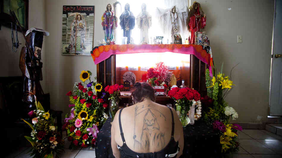 Claudia Rosales kneels in front of her home altar devoted to Santa Muerte, or Saint Death. Rosales put up a statue of the saint in the city that was taken down by the mayor of Matamoros. Claudia Rosales kneels in front of her home altar devoted to Santa Muerte, or Saint Death. Rosales put up a statue of the saint in the city that was taken down by the mayor of Matamoros.