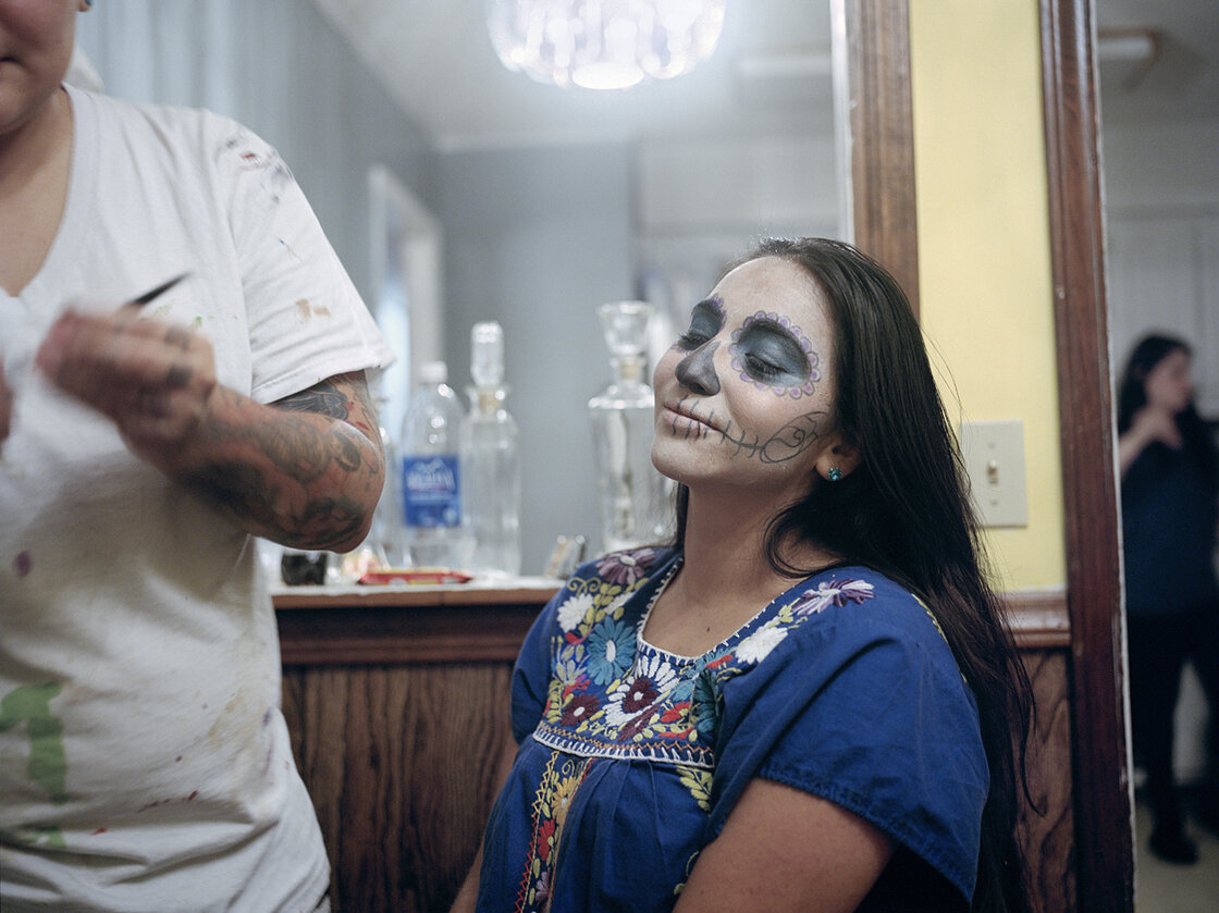 Anai Saucedo has her face painted with makeup in the Dia de los Muertos tradition in Erwin, Tenn.