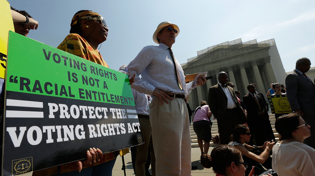 Supporters of the Voting Rights Act listen to speakers discussing the Supreme Court's rulings outside the court building in June 2013. The court ruled that Section 4 of the Voting Rights Act, aimed at protecting minority voters, is unconstitutional. (Image credit: Getty Images)