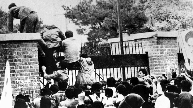 Iranian students climb over the wall of the U.S. Embassy in Tehran during the Iranian Revolution, Nov. 4, 1979. The students went on to seize the embassy staff, and hold 52 of them as hostages for 444 days. (Image credit: AFP/Getty Images)