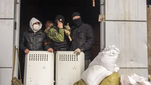 Masked pro-Russia activists guard an entrance to the Ukrainian regional office of the Security Service in Luhansk, 20 miles west of the Russian border, in Ukraine, on Wednesday.