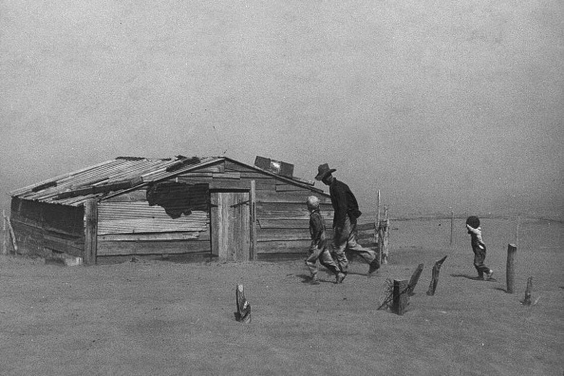 Father and sons walk through a dust storm in Cimarron County, Okla. (1936) Steinbeck writes: "The dust was evenly mixed with the air, an emulsion of dust and air. Houses were shut tight, and cloth wedged around doors and windows, but the dust came in so thinly that it could not be seen in the air, and it settled like pollen on the chairs and tables, on the dishes."