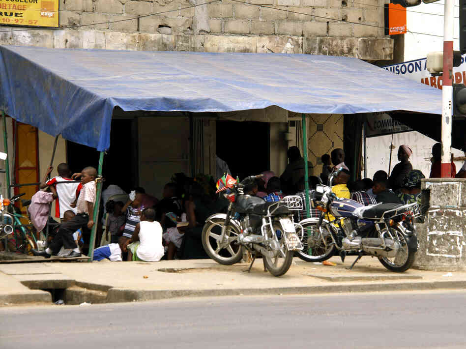 Pentecostal worshipers sit at Ministry Faith Banner's overflow section on a street corner in Douala. Pentecostal worshipers sit at Ministry Faith Banner's overflow section on a street corner in Douala.
