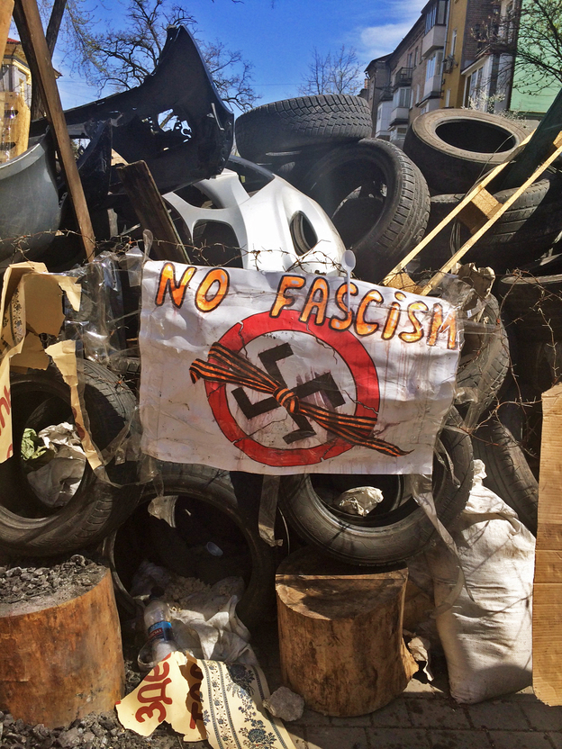 An anti-fascist sign hangs on the barricade outside an occupied government building in Donetsk. (Image credit: NPR)