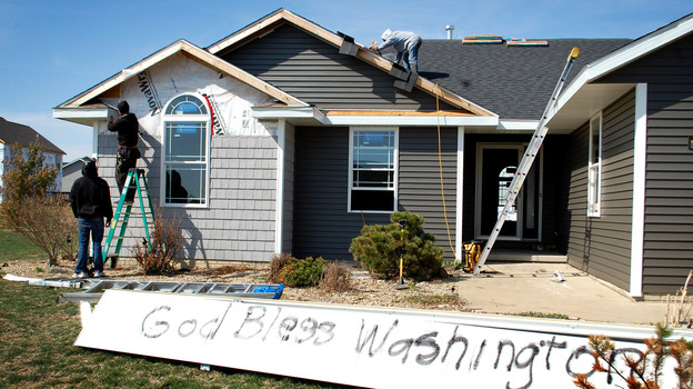 Washington, Ill., is full of both optimistic signs and lots of construction crews as the town rebuilds after a half-mile-wide tornado devastated the area in November. (Image credit: NPR)