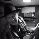 Neil Young in a recording booth, tracking a cover of Bert Jansch's "Needle Of Death." Neil Young in a recording booth, tracking a cover of Bert Jansch's "Needle Of Death."