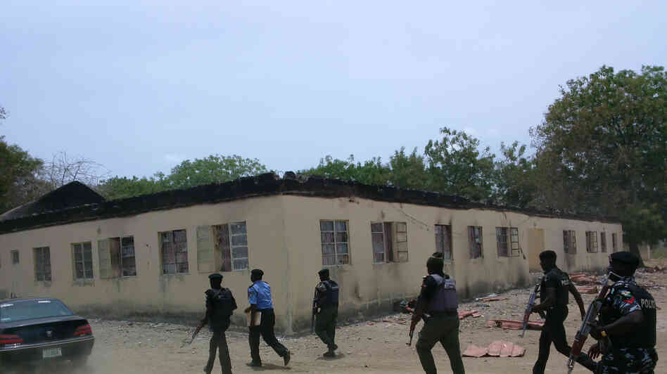 Security walk past the secondary school in Chibok, Nigeria, where gunmen abducted more than 200 students. The government has been criticized for its response to the incident. Security walk past the secondary school in Chibok, Nigeria, where gunmen abducted more than 200 students. The government has been criticized for its response to the incident.