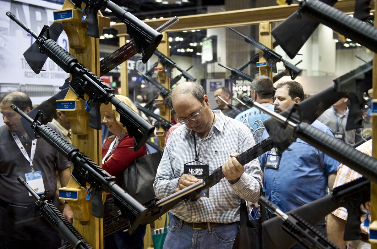 A man examines weapons in the exhibit hall at the 143rd NRA Annual Meetings and Exhibits at the Indiana Convention Center in Indianapolis.