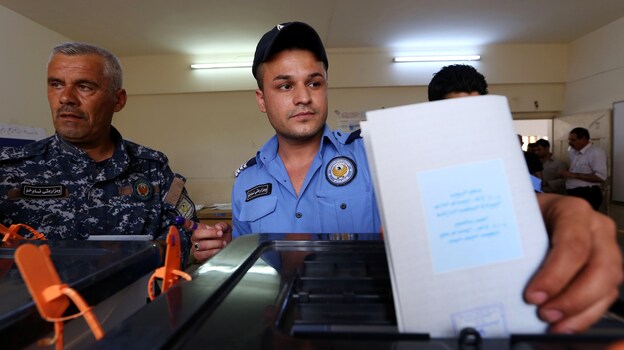 A Kurdish Iraqi policeman in the northern Kurdish city of Erbil casts his ballot Monday in special voting ahead of Wednesday's election. (Image credit: AFP/Getty Images)