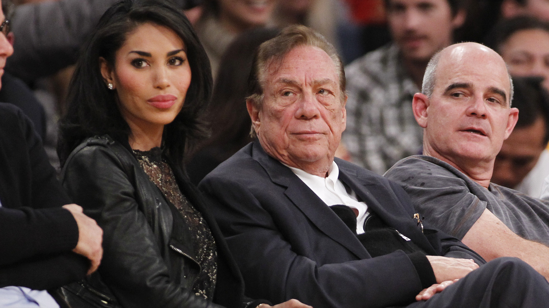 Los Angeles Clippers owner Donald Sterling (center) has been banned by the NBA; he is seen here watching a Clippers game with former girlfriend V. Stiviano.