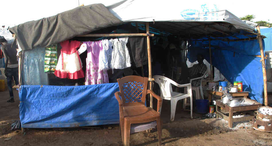 A kiosk in the Juba camp sells girls' dresses. "People buy it for a holiday," says the owner. Weddings are held in the camp as people are too scared to leave for fear they'll be targeted for their ethnicity. A kiosk in the Juba camp sells girls' dresses. "People buy it for a holiday," says the owner. Weddings are held in the camp as people are too scared to leave for fear they'll be targeted for their ethnicity.