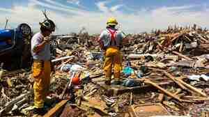 After a tornado leveled Moore, Okla., last year, firefighter Shonn Neidel (left) developed an app that helps first responders locate storm shelters under the wreckage.