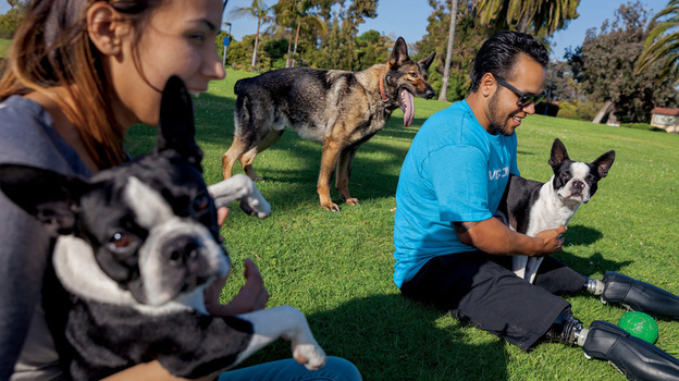 In this image from the June issue of National Geographic, Jose Armenta and his wife, Eliana, relax with their Boston terriers Oreo and Sassy, and Zenit, a German shepherd they adopted from the Marines. (Image credit: National Geographic )