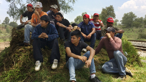 Migrants from Central America rest alongside the railroad tracks outside Huehuetoca. The group is waiting to jump aboard a freight train headed toward the U.S. border. Of the 15, there are three minors, all traveling alone.