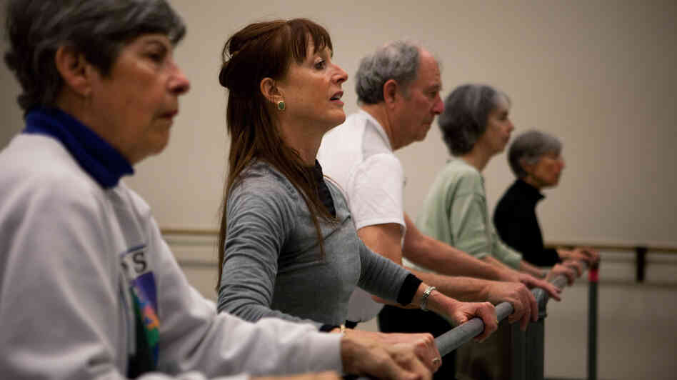 Dance teacher Lucy Bowen McCauley (second from left) finds that simply humming can help her students with Parkinson's get their feet to "unfreeze" and match the song's rhythm. Dance teacher Lucy Bowen McCauley (second from left) finds that simply humming can help her students with Parkinson's get their feet to "unfreeze" and match the song's rhythm.