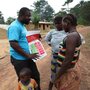 A UNICEF field worker talks to villagers in Liberia's Foya District about how to prevent Ebola disease.