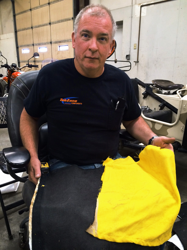 David Turbyfill holds a firefighter's shirt after testing a fireproof fabric he found on the Internet. (Image credit: KJZZ)