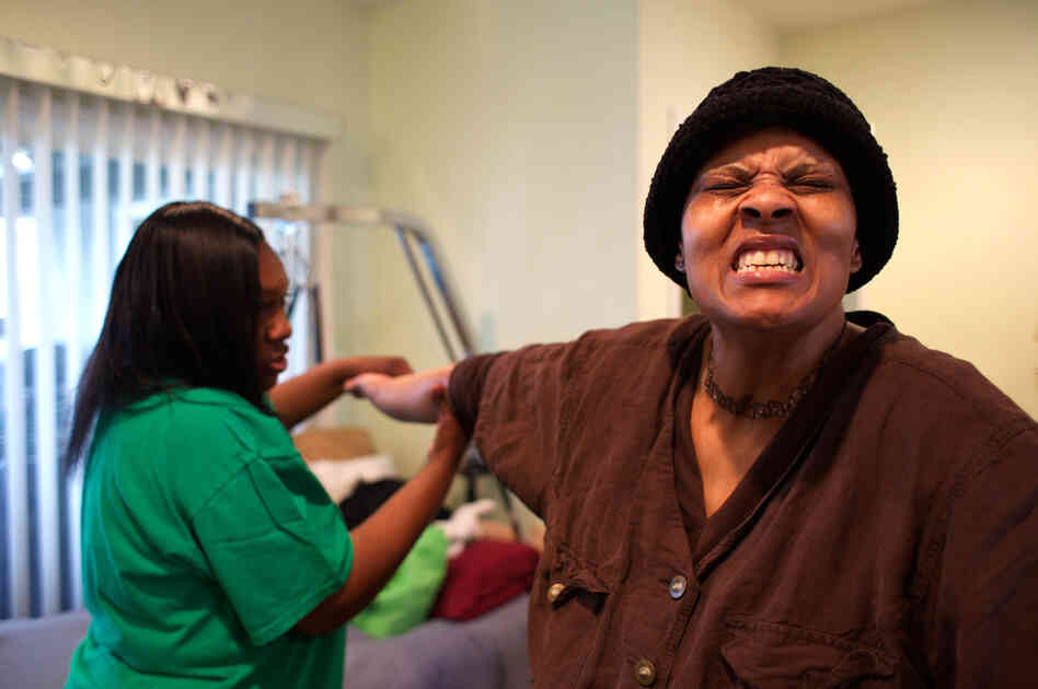 Loretta Jackson gently stretches the hands of her sister, Shirlene English, to aid physical rehabilitation after Shirlene's brain aneurysm and stroke. Loretta Jackson gently stretches the hands of her sister, Shirlene English, to aid physical rehabilitation after Shirlene's brain aneurysm and stroke.