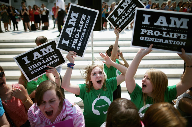 Anti-abortion advocates cheer in front of the Supreme Court on June 30 after hearing the ruling that some for-profit companies can refuse to offer contraceptive coverage on religious grounds.