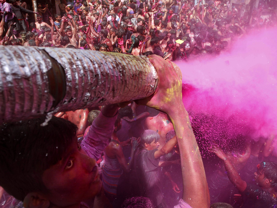 A man sprays colored dye on people dancing during Holi celebrations in India in 2012. Holi, the Hindu festival of colors, also heralds the coming of spring — a detail that partiers at the Shout Color Throw might miss.