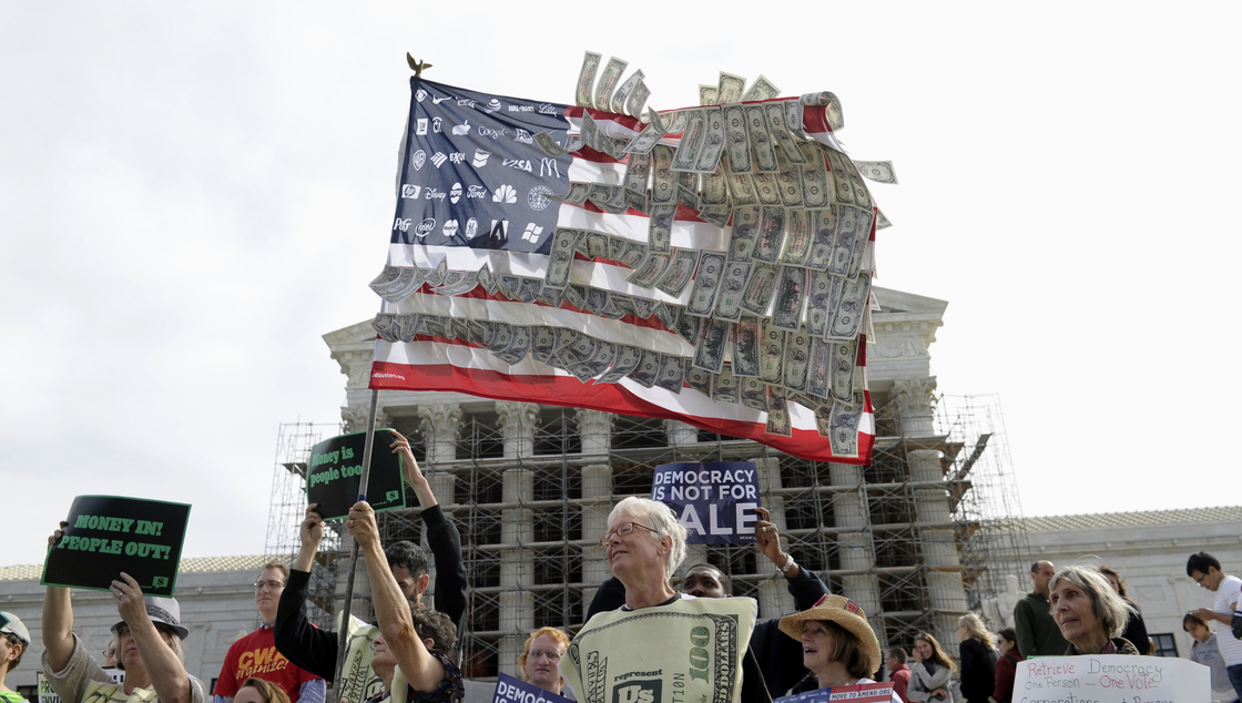Demonstrators gather outside the Supreme Court on Oct. 8, 2013, as the court hears arguments on campaign finance. The court ultimately struck down a cap on contributions to political parties in each election.