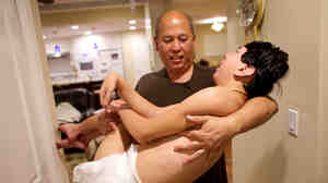 James Lee often has to pick up his 100-pound son, Justin. Photographer Andrew Nixon shot this photo in an effort to show how being caregivers affects the aging parents.