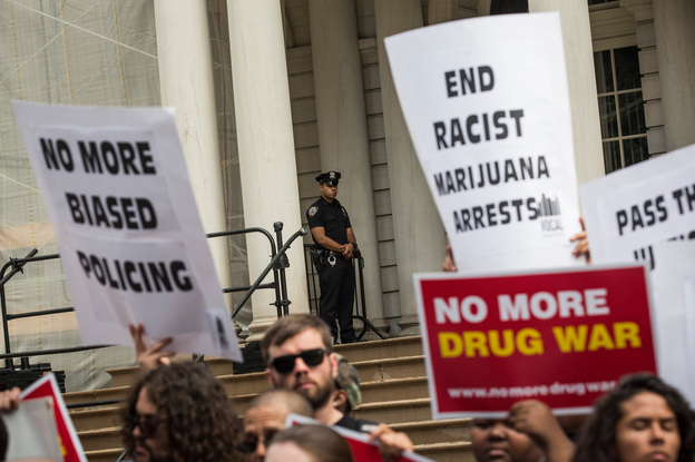 Outside New York City Hall, a policeman watches a protest against racial disparities in marijuana arrests. The majority of those arrested are black or Latino, even though those groups are not more likely to smoke pot. (Image credit: Getty Images)