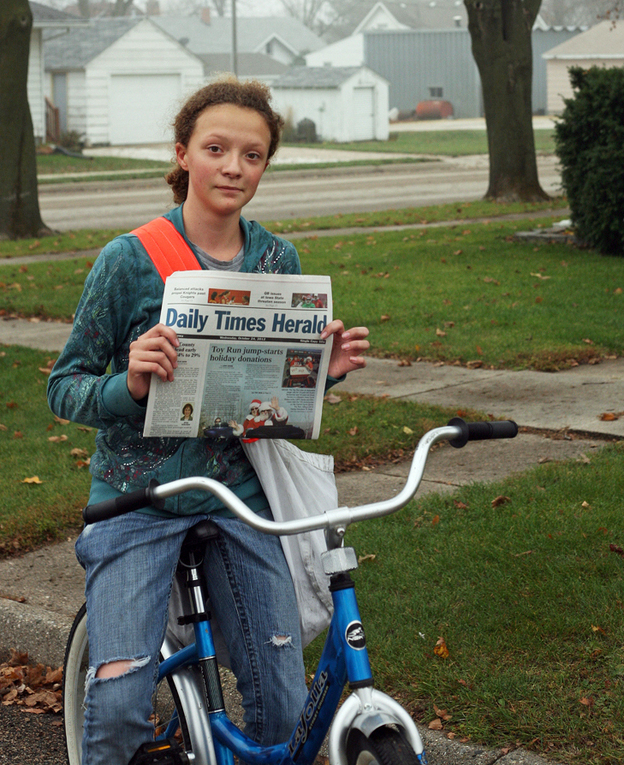 Meridith Beeber on her paper route in Templeton, Iowa in 2012. Eighty percent of The Daily Times Herald's papers are delivered by young people. (Image credit: Noah Adams for NPR)