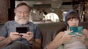 Robin Williams and daughter Zelda Williams play the Nintendo 3DS in an image from a promotional video. Williams, an avid gamer, died earlier this week.