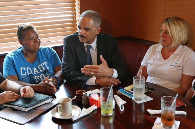 Attorney General Eric Holder talks with Ferguson, Mo., residents Angela Whitman (left) and Jill Richards on Wednesday at Drake's Place Restaurant about issues surrounding the shooting of Michael Brown. (Image credit: MCT/Landov)