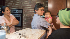 Carballo's wife, Carla Naranjo, and his son look on as he holds his 1-year-old daughter, Reina de la Paz. Her name means 