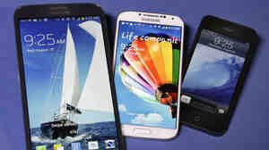The Samsung Galaxy Mega (from left), Samsung Galaxy S4 and Apple iPhone 5 are shown. Apple is expected to announce larger models of its smartphone on Tuesday.