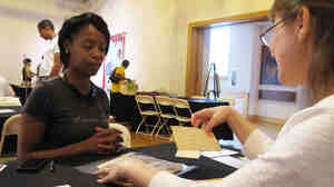 Neonta Williams (left) shares family letters dating back to 1901 with preservationist Kimberly Peach during the Smithsonian's Save our African American Treasures program at the Birmingham Civil Rights Institute. Peach advises her to use archive-quality polyester sleeves to protect the fragile papers, rather than store them in a zip-lock bag.