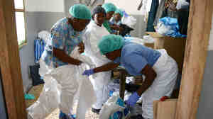 Medical workers in Monrovia, Liberia, put on their protective suits before treating Ebola patients