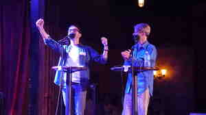 John Cameron Mitchell (right) and contestant Jordan Shavarebi celebrate a victory during their Ask Me Another Challenge.