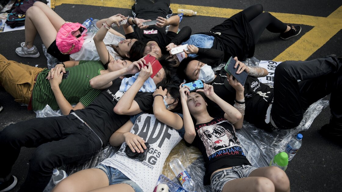 People check their phones at a pro-democracy demonstration in Hong Kong on Monday.