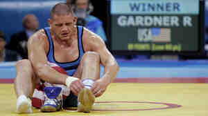 Rulon Gardner took off his shoes to symbolize his retirement after defeating Sajad Barzi, of Iran, during the men's Greco-Roman 120kg wrestling bronze medal bout at the 2004 Olympic Games in Athens.