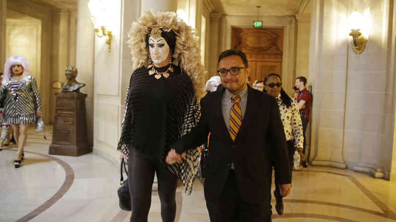 San Francisco City Supervisor David Campos (right) walks with drag queen Sister Roma to a news conference on Sept. 17 about a Facebook policy that requires people to use their "real" names on their profiles. The site said Wednesday it will modify how the policy is enforced.