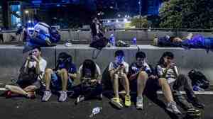 Protesters rest following pro-democracy protests in Hong Kong on Sept. 29. They're using old and new forms of tech to stay connected.