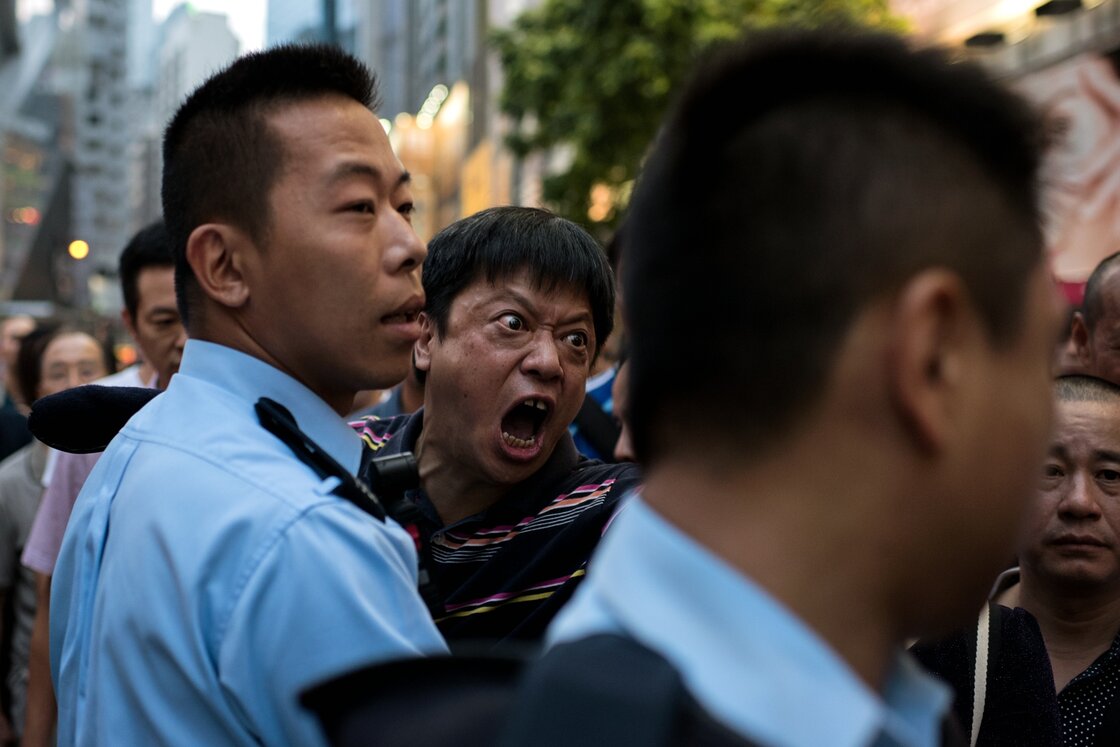 A man is held back by police as he screams at pro-democracy protesters to stop occupying an area of the Causeway Bay district. A man is held back by police as he screams at pro-democracy protesters to stop occupying an area of the Causeway Bay district.