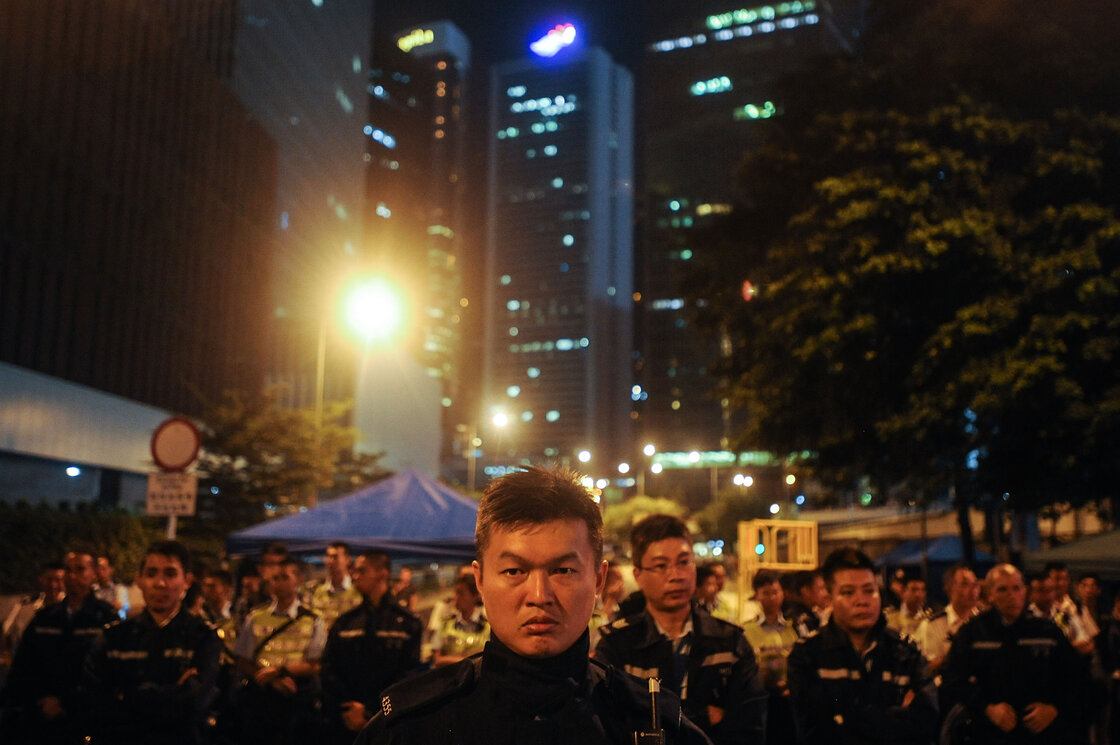 Police stand guard outside the government headquarters Friday in Hong Kong. Police stand guard outside the government headquarters Friday in Hong Kong.