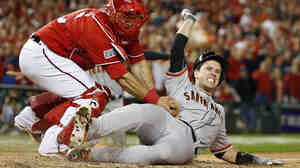 Nationals catcher Wilson Ramos tags out Giants' Buster Posey in the ninth inning. It was the longest postseason game in MLB history.