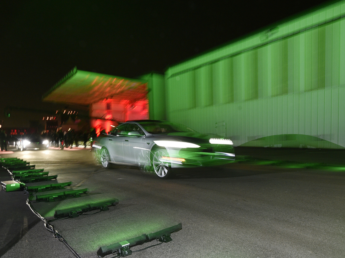 Tesla owners take a ride in the new Tesla "D" model Thursday after Elon Musk, CEO of Tesla, unveiled the dual engine chassis, a faster and all-wheel-drive version of the Model S electric sedan, at the Hawthorne Airport in Hawthorne, Calif. The D will be able to accelerate to 60 miles per hour in just over three seconds.