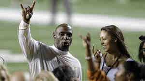 University of Texas football coach Charlie Strong holds up the "Hook' em Horns" sign as he sings the school song following an NCAA game against North Texas on Aug. 30. Texas won 38-7.